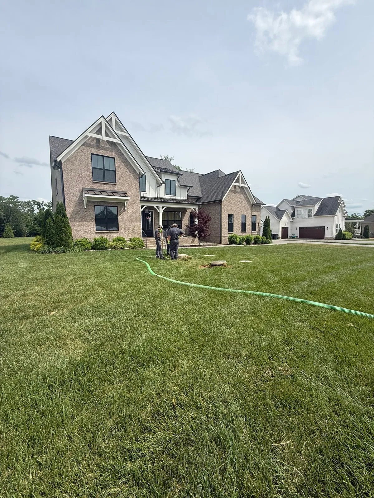 Yard graded out in front of a brick home after septic work