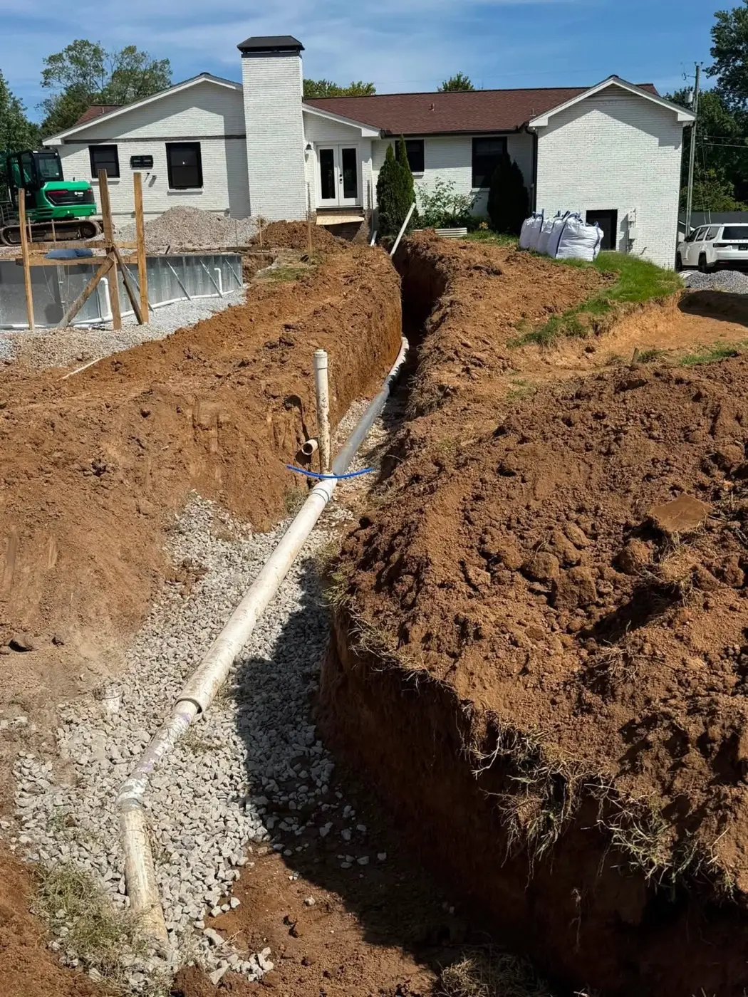 Septic line rough in trenched beside a home under construction