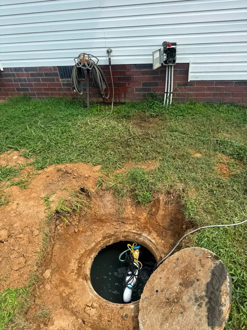 Septic pump and float switch exposed in an opened tank during a repair call